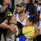 Stephen Curry of the Golden State Warriors celebrates holding daughters Riley and Ryan after defeating the Cleveland Cavaliers 129-120 in Game 5 to win the 2017 NBA Finals on June 12, 2017 in Oakland, California.